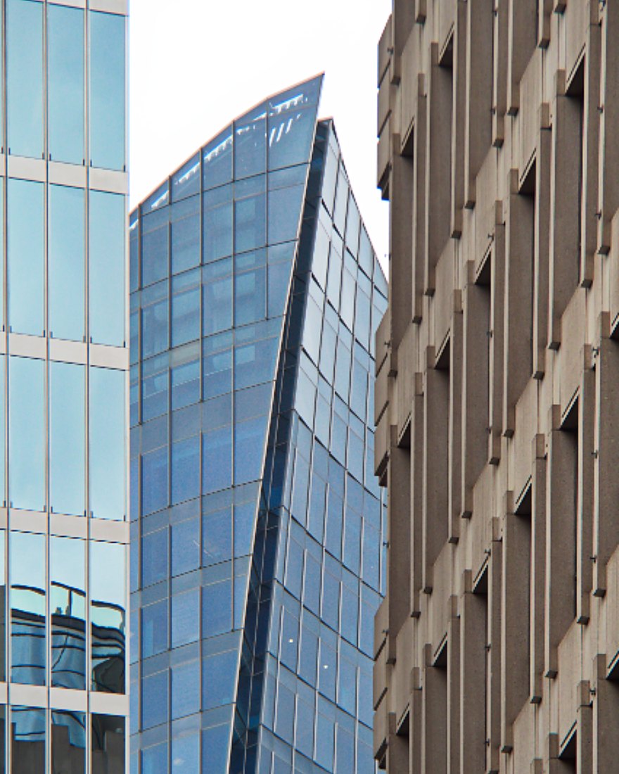 Modern glass and stone office towers seen from street level.